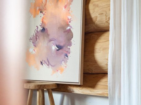 Abstraktes Gemälde in Holzhaus. Abstrakte Malerei mit lila und orangefarbigen Farbtönen, in einem Holzhaus.