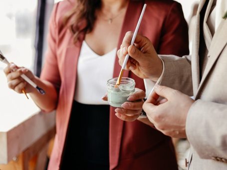 Wedding-Painting – Hochzeitsmalerei – Künstlerisches Gästebuch Zwei Personen halten Pinsel und malen auf einer Hochzeit mit Farbe.