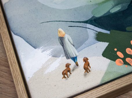 Detaillierte Zeichnung – Auftragsarbeit – Auftragskunst Eine Person mit blonder Haarfarbe geht mit zwei braunen Hunden – Dackeln –am Strand spazieren.